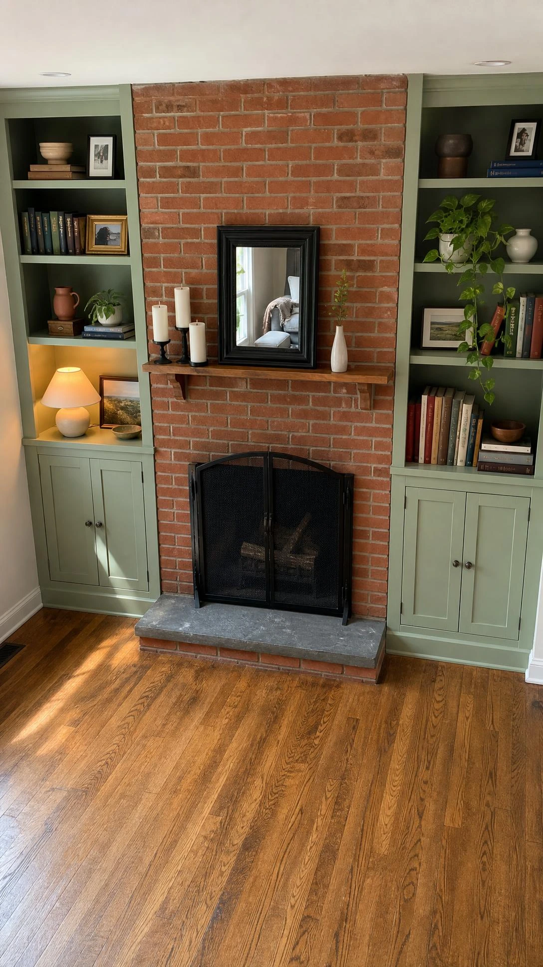 Classic red brick fireplace flanked by floor-to-ceiling built-in shelving units, shot from overhead to show the symmetrical living room layout