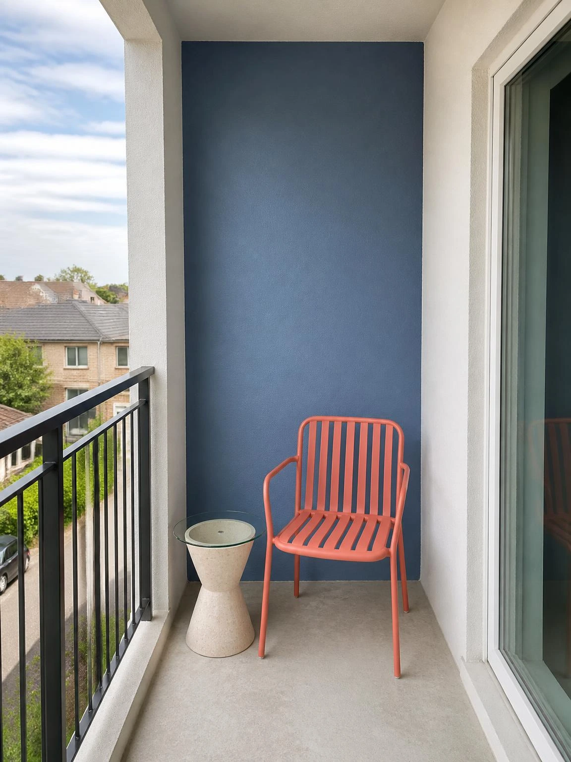 Balcony blue accent wall in a compact contemporary space, paired with a coral chair and pale stone table for attainable outdoor style