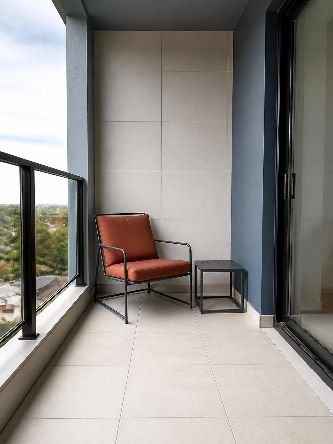 Balcony decoration with a slim steel lounge chair, terracotta cushion, and side table in a calm tiled reading nook
