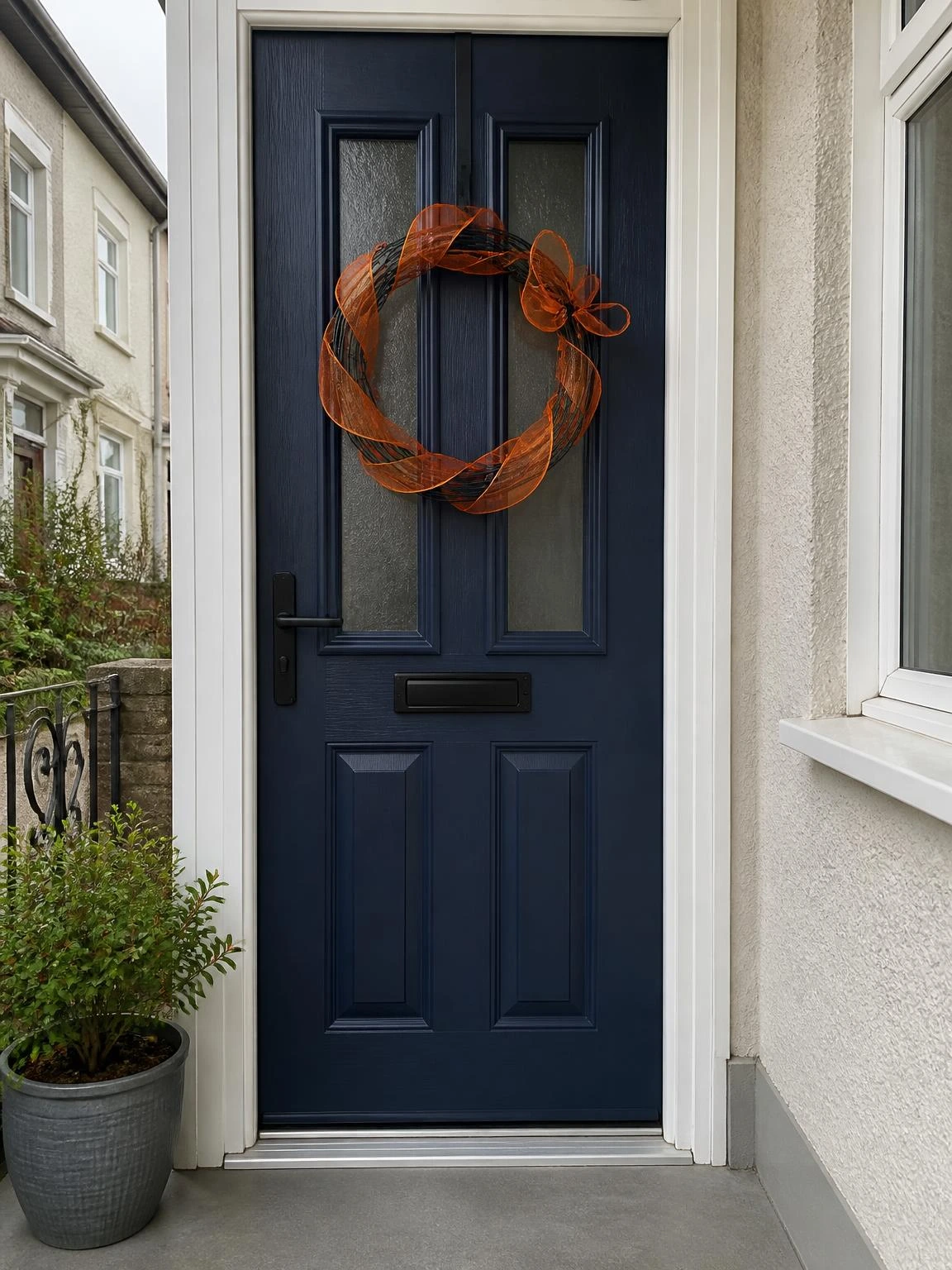 5- Black Door Wreath with Orange Ribbon - halloween porch ideas for small spaces