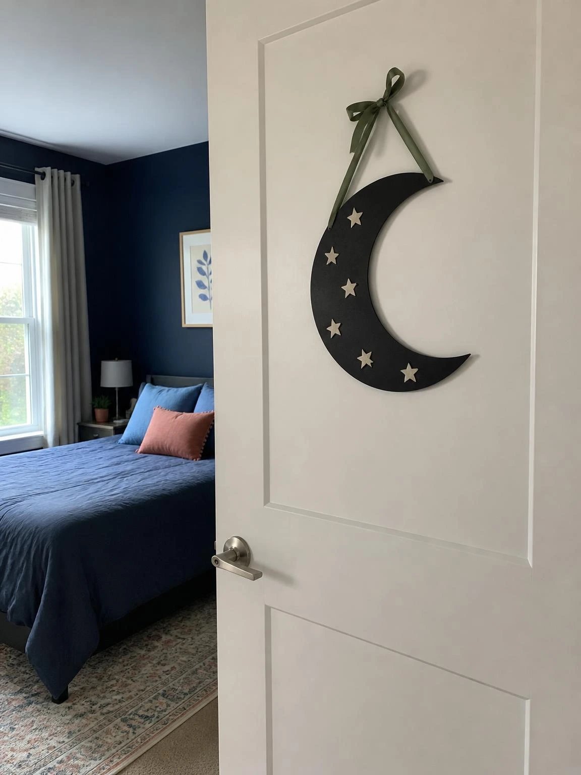 Black crescent moon door sign with ivory stars and green ribbon introduces cheap Halloween bedroom decor beside a navy bedroom.