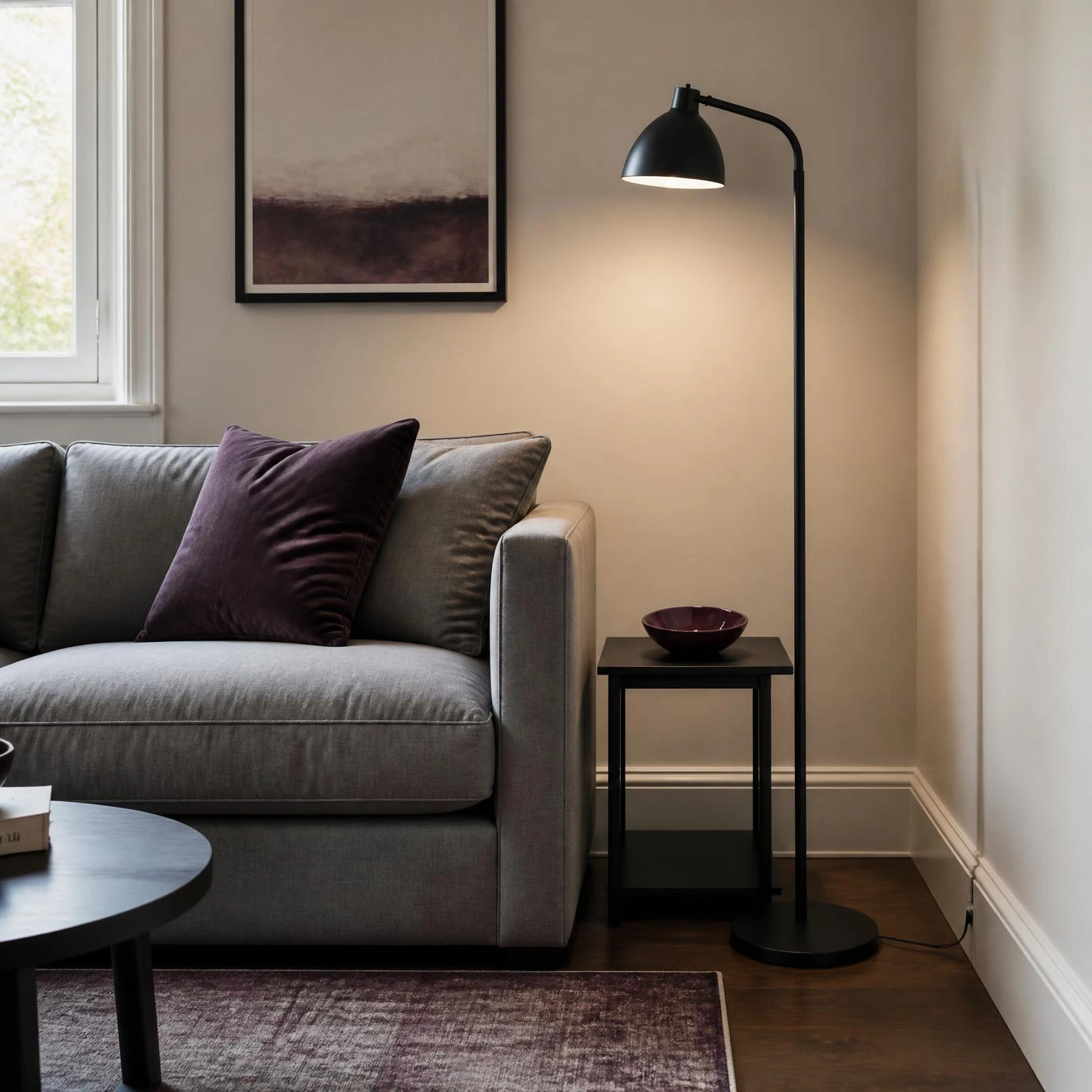 Fall living room decor area with a black floor lamp beside a warm gray sofa and plum-accented side table