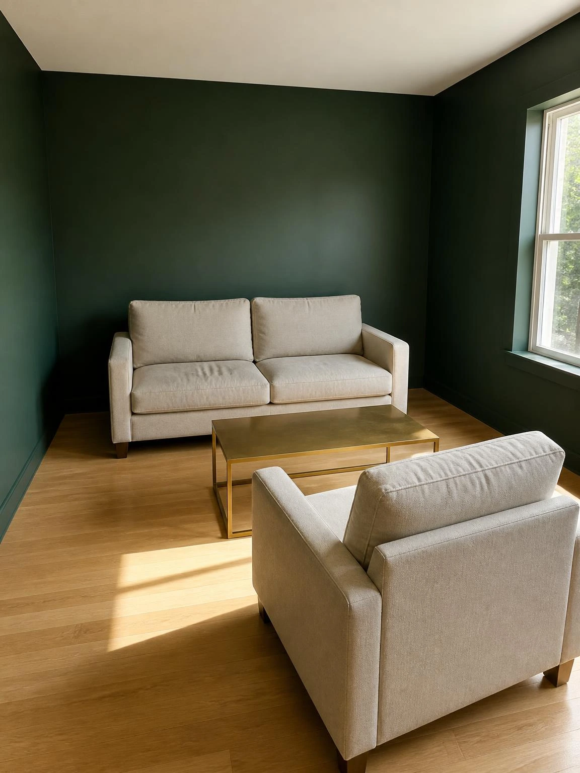 Forest green living room with only a linen sofa, armchair, and brass coffee table showing minimal home decor ideas at their most restrained