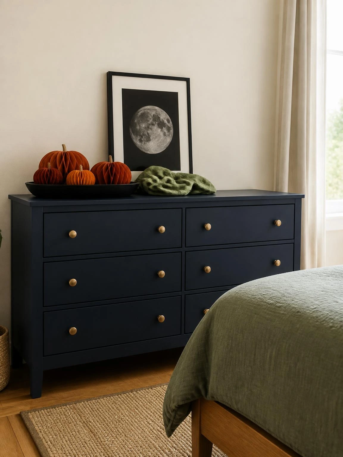 Budget Halloween dresser display with paper pumpkins, moon print, and green fabric on a usable navy dresser