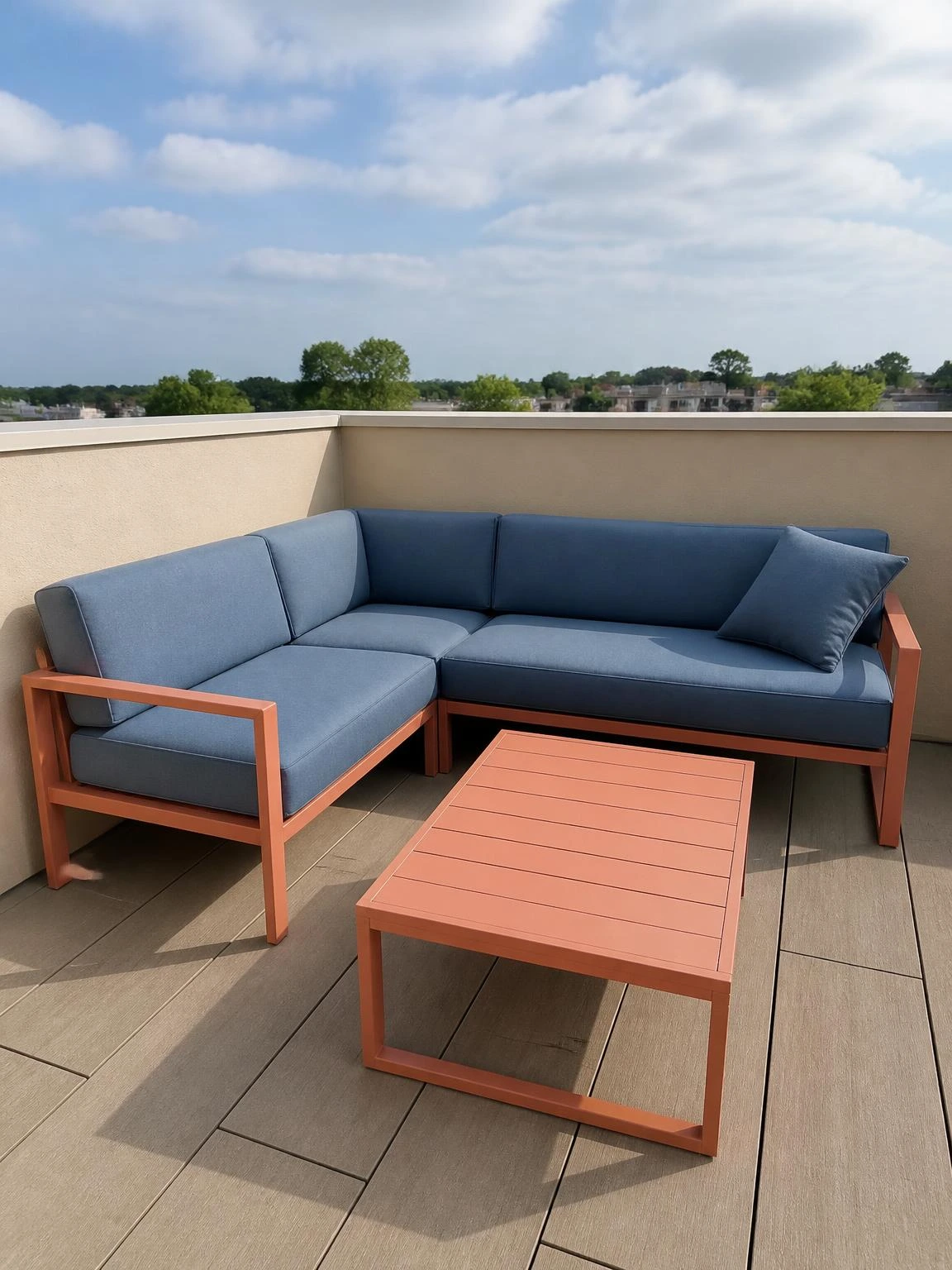 L-shaped modular outdoor sofa in soft coral aluminium frames tucked into a compact rooftop terrace corner, muted blue foam cushions catching midday light