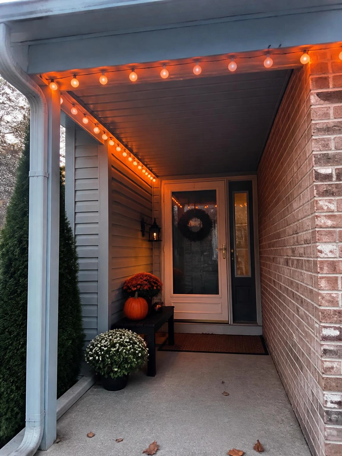 9- Orange String Lights Along a Porch Overhang - halloween porch ideas for small spaces