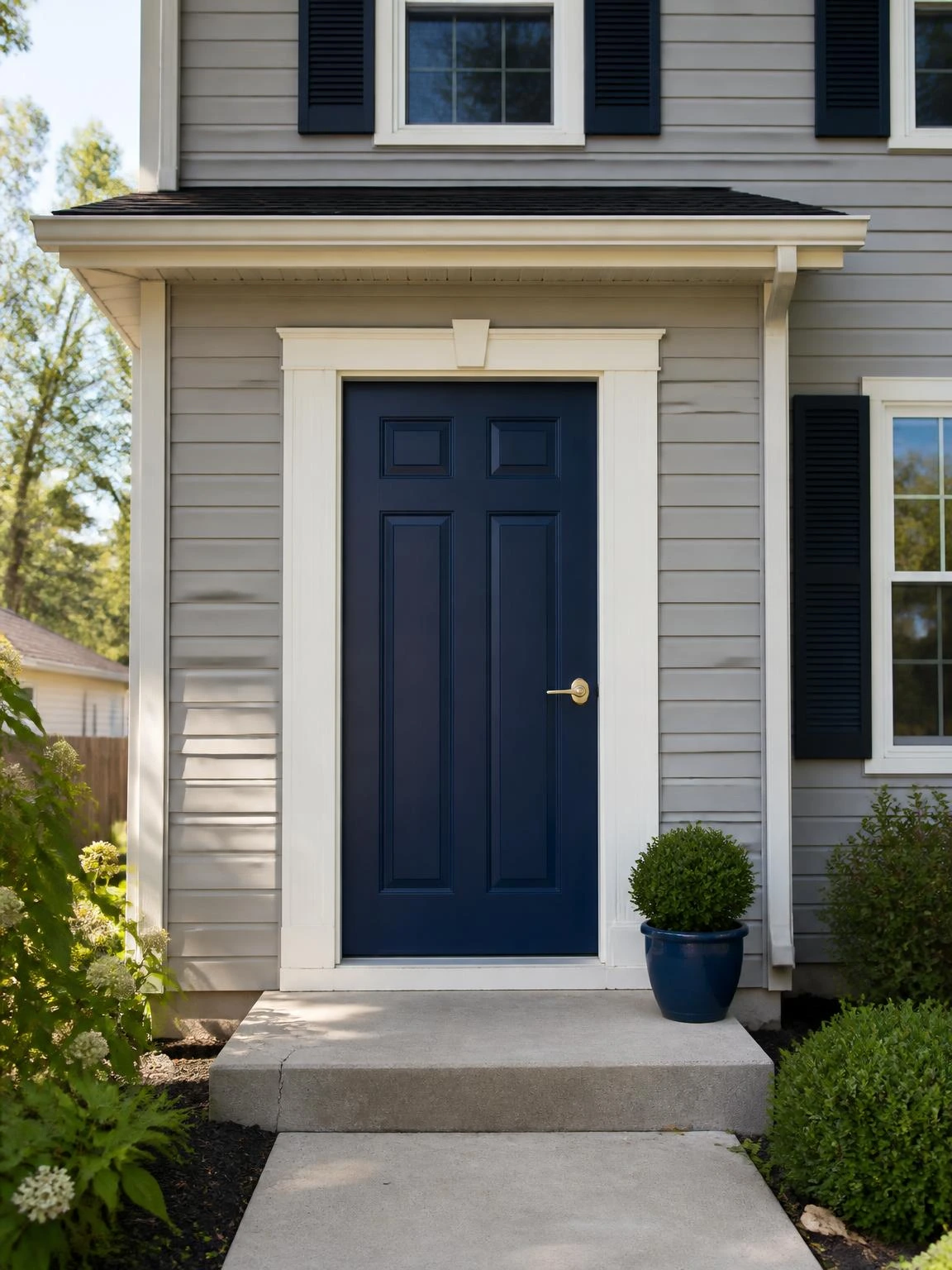 Navy-painted front door with ivory trim and brass lever handle on a suburban home, showing how a bold color boosts curb appeal instantly