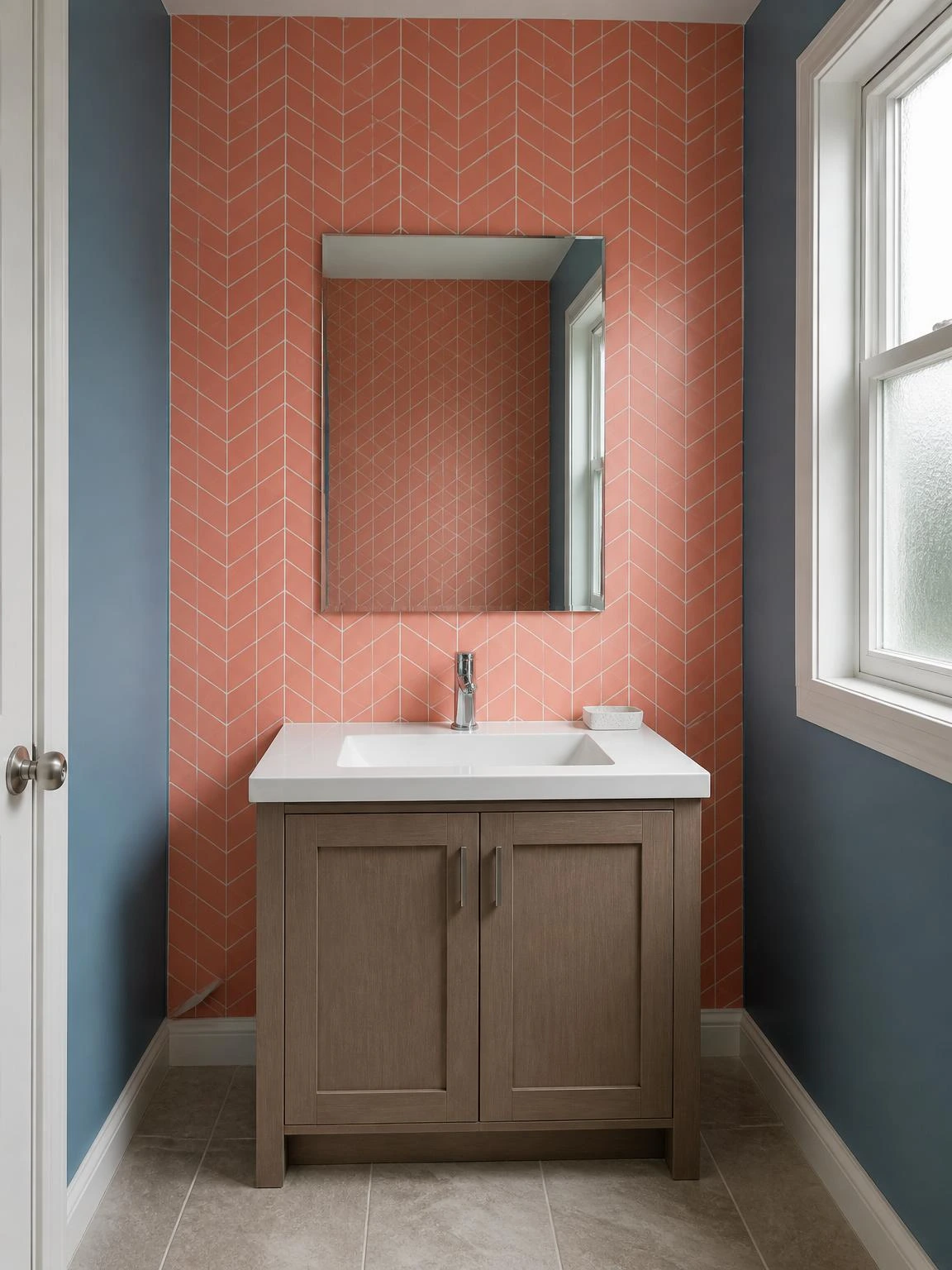 Compact bathroom vanity wall covered in coral geometric peel-and-stick vinyl tiles, reflected in a frameless mirror against dusty blue side walls