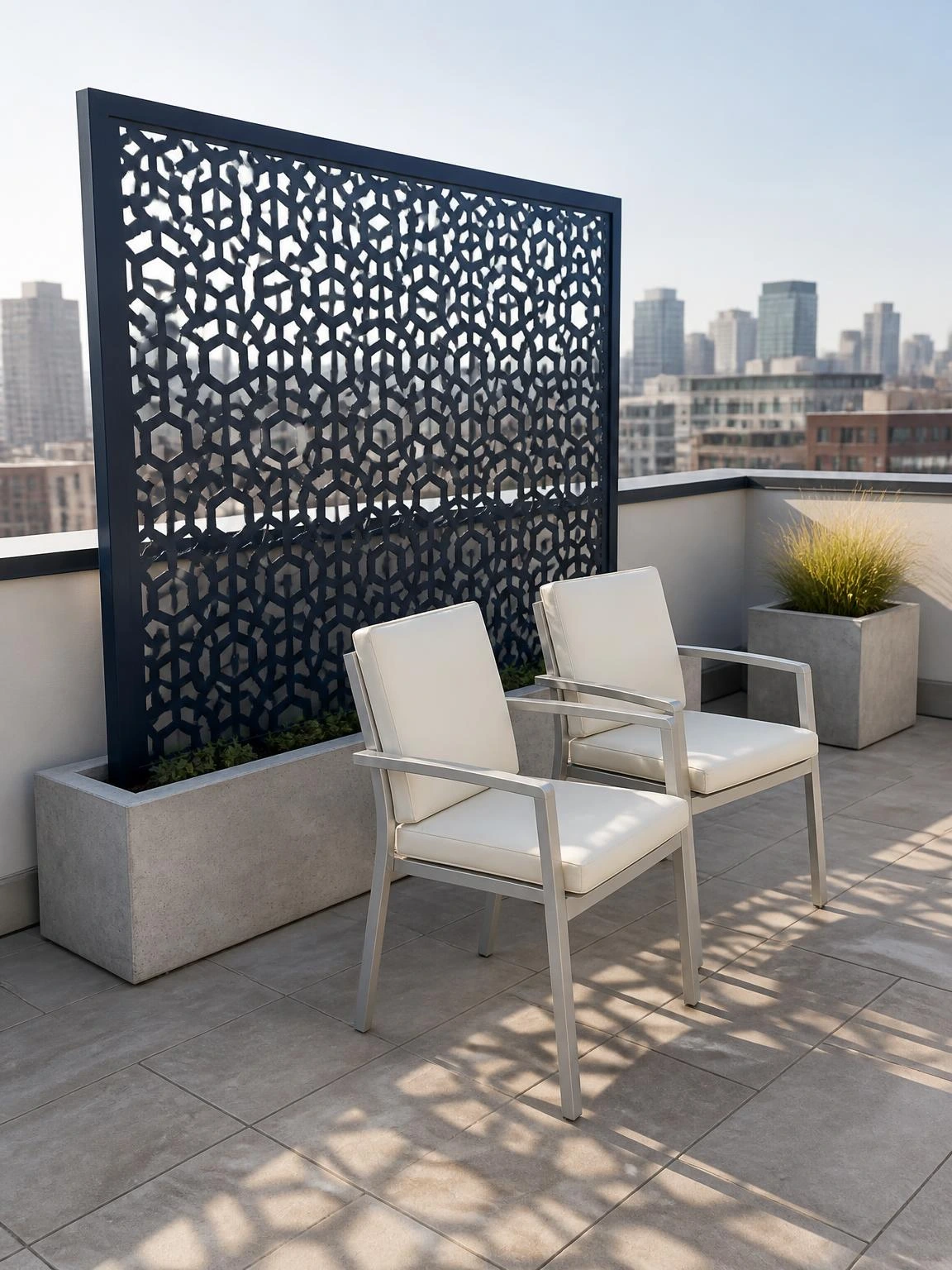 Freestanding navy steel privacy screen with hexagonal lattice pattern anchored in a concrete ballast planter on a small rooftop terrace, no roof penetrations needed